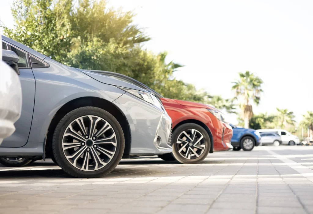 Row of parked cars in sunlight.