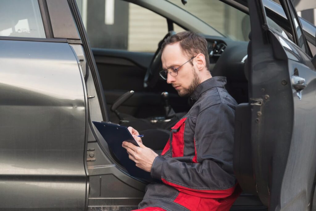 Mechanic inspecting vehicle with clipboard